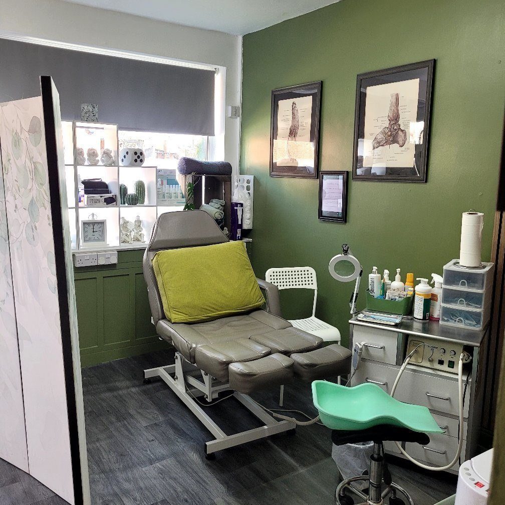 The Foot Chamber treatment room — calm, sage-walled, anatomical prints on the walls